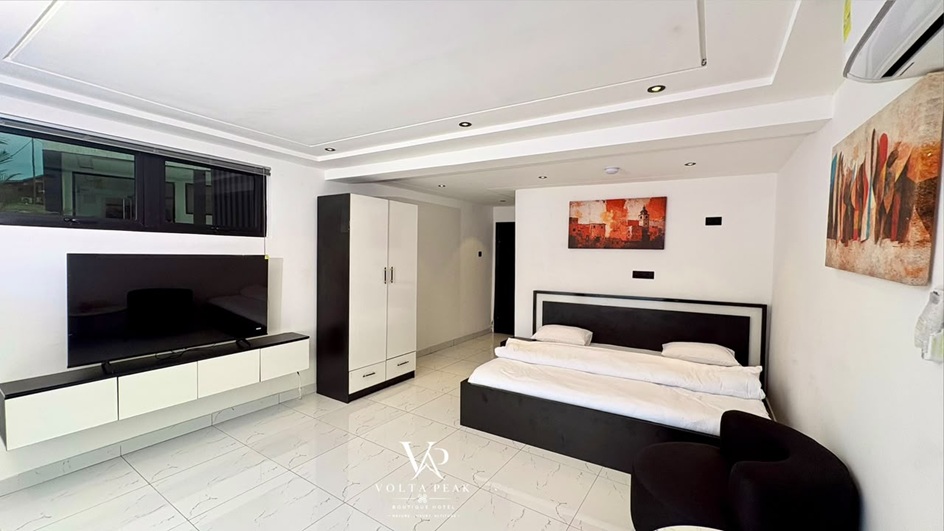 Executive suite with large TV, wardrobe and king bed