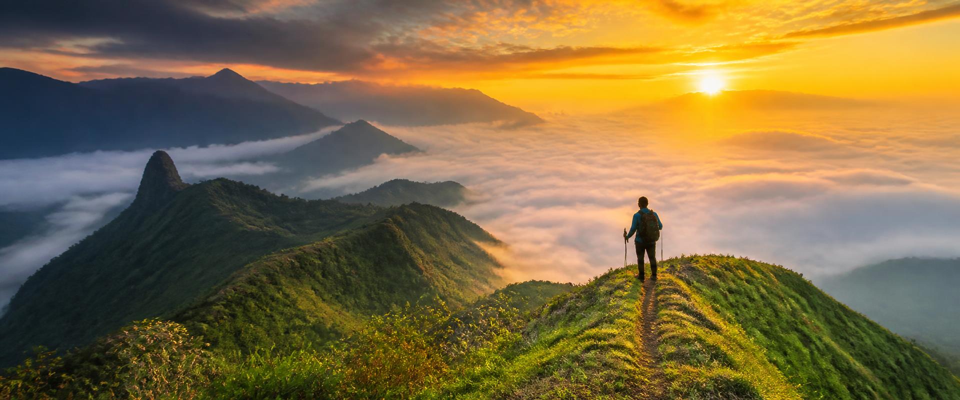Hiker overlooking misty mountain peaks